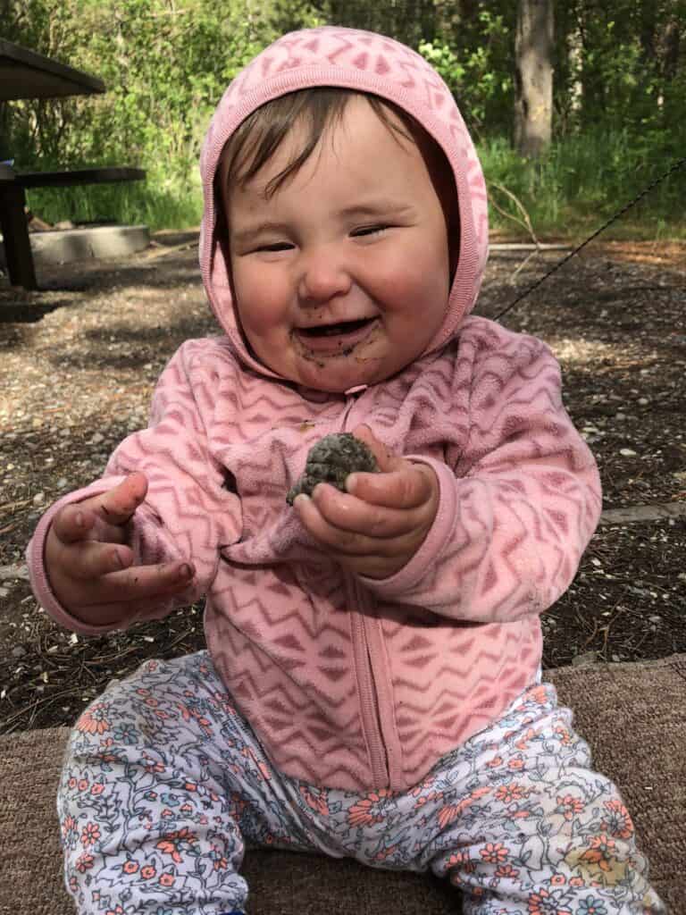 baby play with pinecone in nature